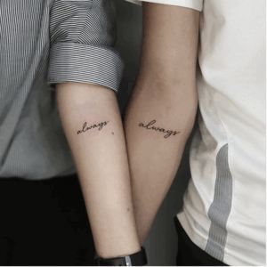 Couple with matching "always" tattoos on their forearms, symbolizing love and commitment, featured in a blog post about unique tattoo ideas for couples.